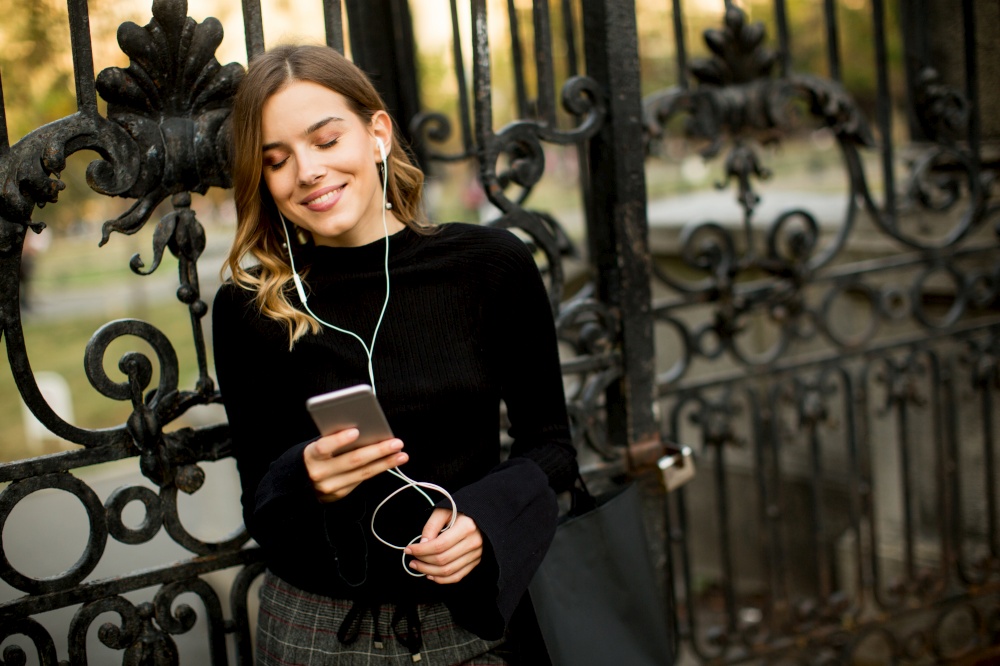 Portrait of young woman  listening music outdoor