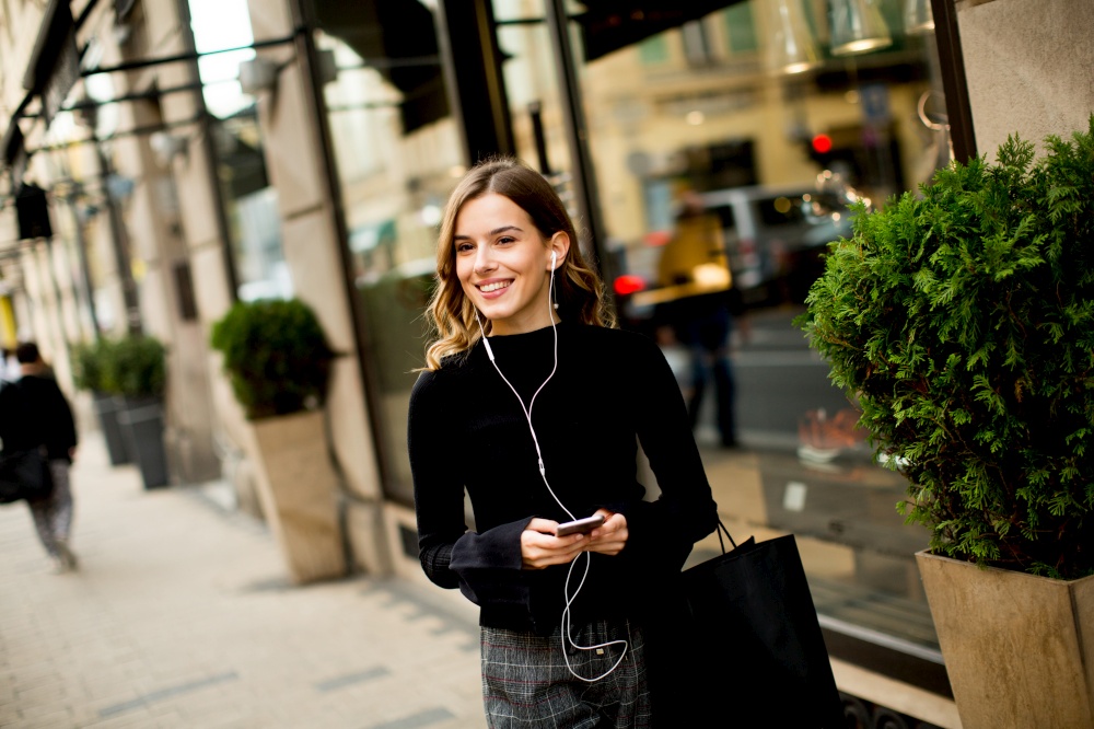Portrait of modern young shopaholic woman on street