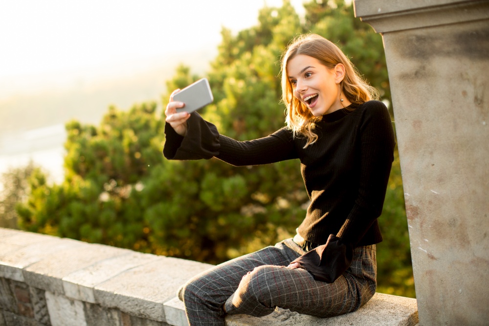 Pretty young woman teking selfie outdoor
