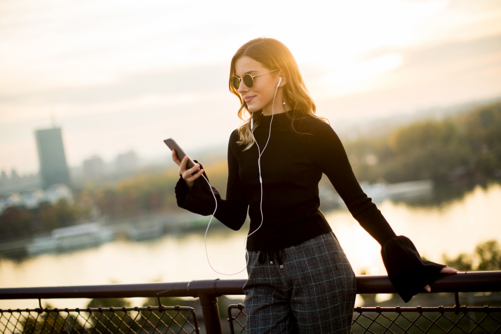 Portrait of attractive young woman with mobile phone outdoor