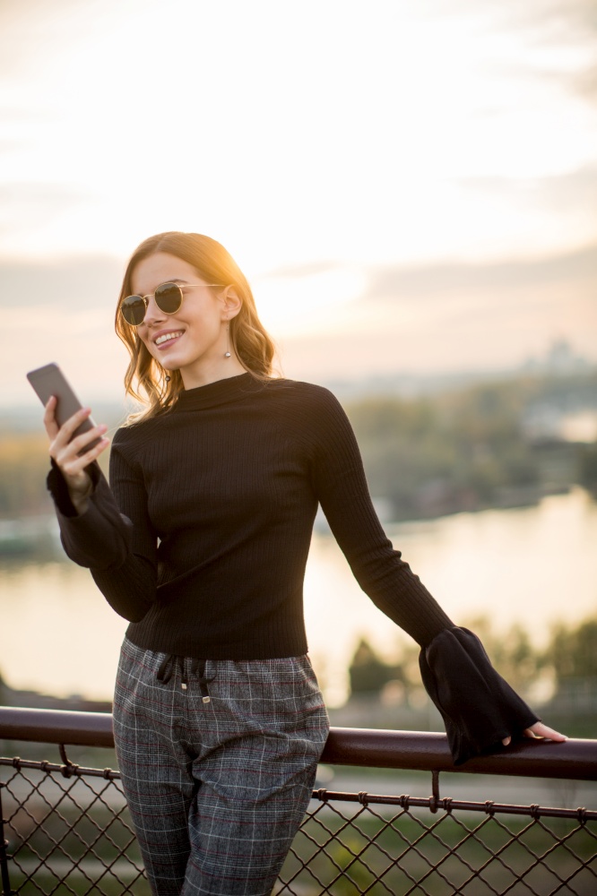 Portrait of attractive young woman with mobile phone outdoor