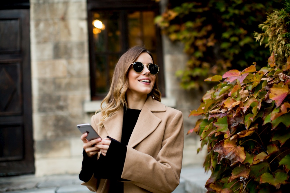 View at modern woman using mobile phone at autumn outdoor