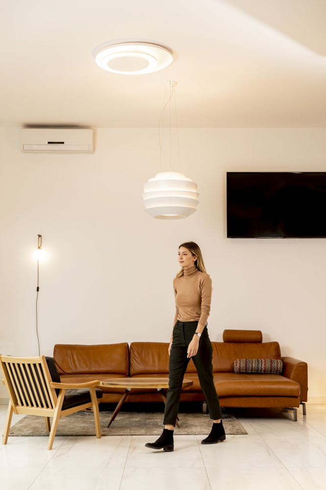 Pertty young woman walking through modern livingroom