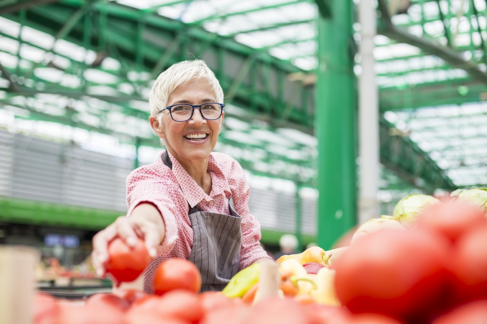 Senior woman sells organic vegetable on market