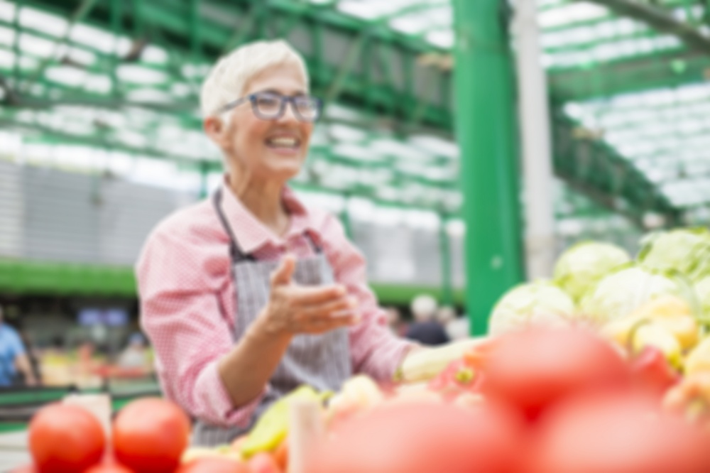 Senior woman sells organic vegetable on market