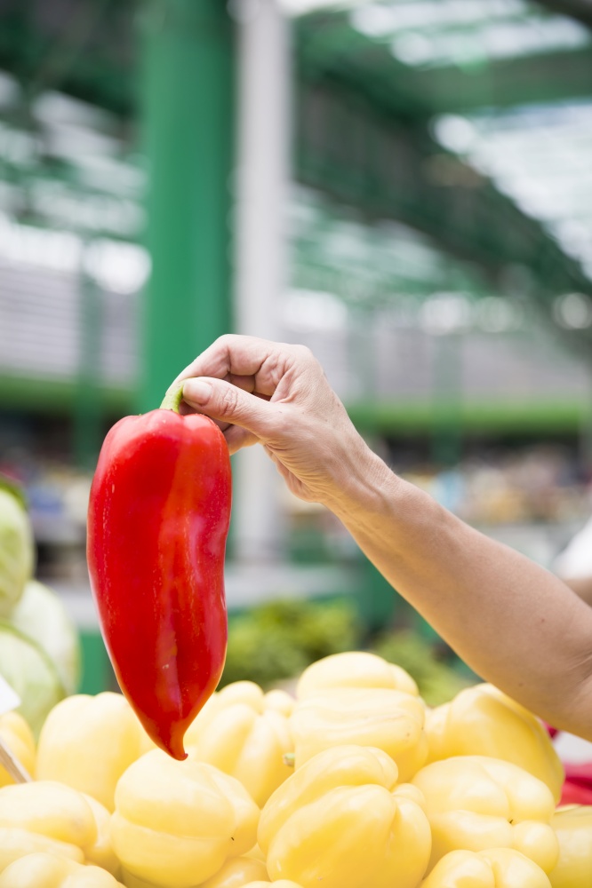 Red pepper in hand on market