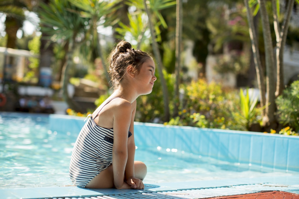 Cute little girl on the poolside on a sunny summer day