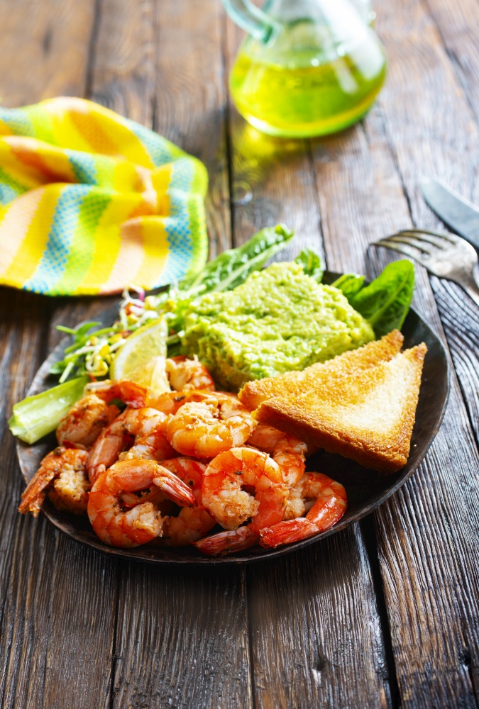 fried shrimps with fresh avocado and toasts. helthy breakfast. fried shrimps with avocado and toasts