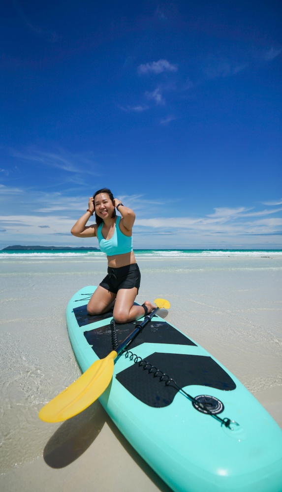 woman on sup board or paddle board at the beach