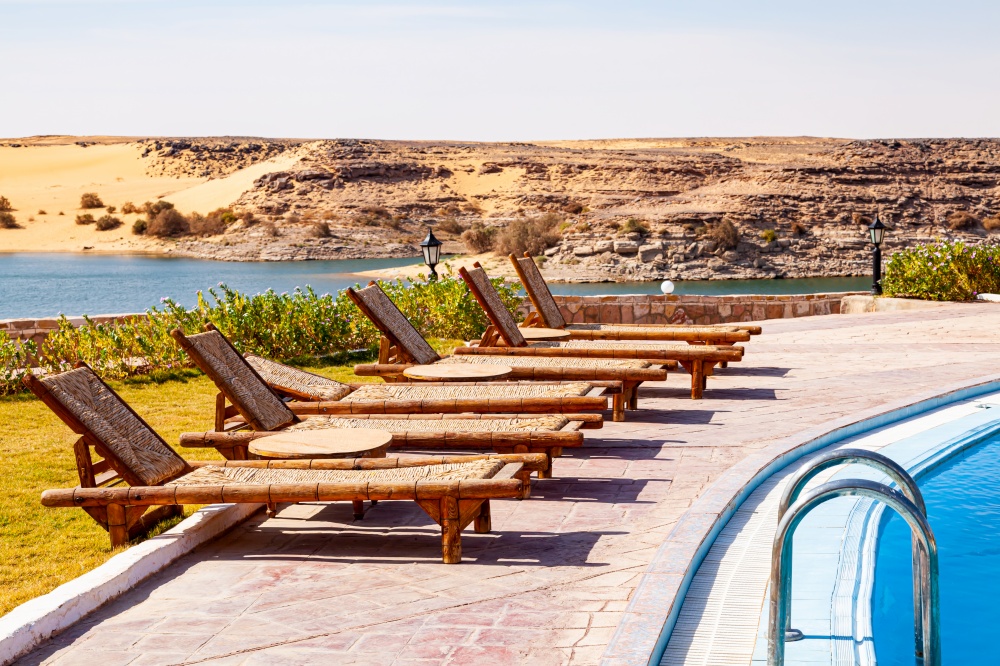 Row of swimming pool lounge chairs with the view of Nasser Lake at Abu Simbel Village, Aswan, Upper Egypt.
