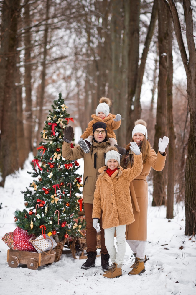 Family Christmas photo with a decorated Christmas tree in nature.. New Years postcard family photo with a Christmas tree in nature 3526.