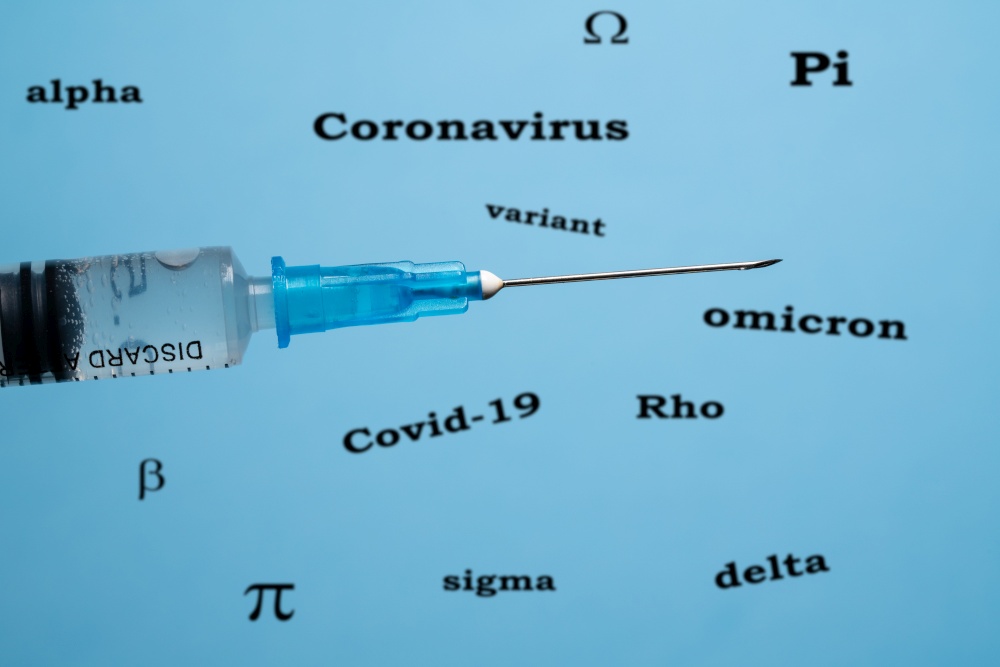 Concept of effectiveness of vaccines against covid-19 with hypodermic syringe in front of words describing coronavirus. Concept of covid-19 variants and effectiveness of vaccines