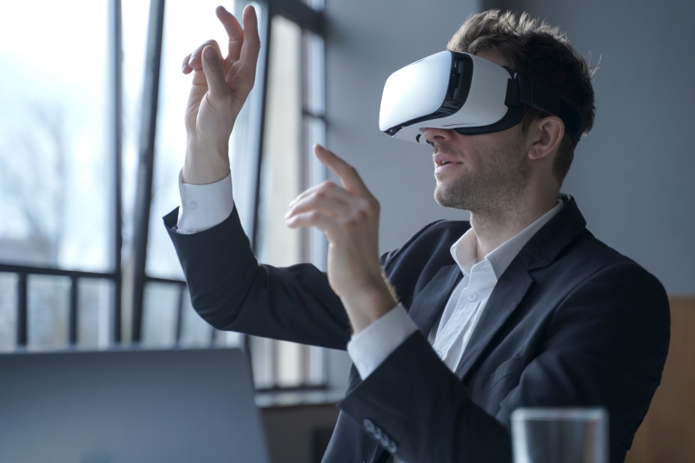 Cyberspace in business. Excited man office worker wearing vr goggles touching objects with hands in digital world, amazed businessman in 3d glasses interacting with virtual reality at work. Excited man office worker wearing vr goggles touching objects with hands in digital world