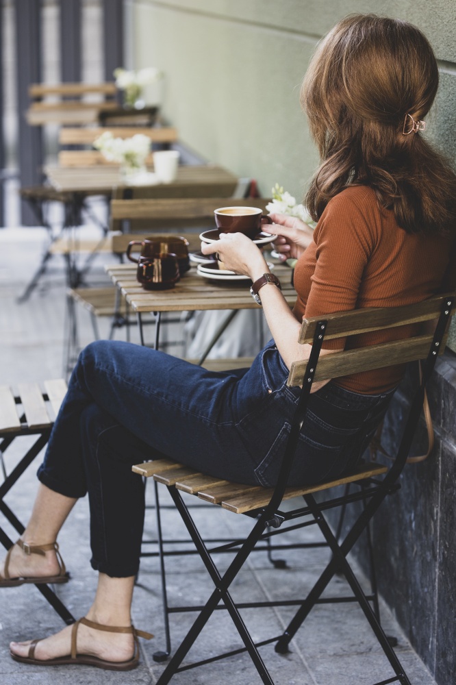 girl drinking coffee on the outdoor terrace in a cafe