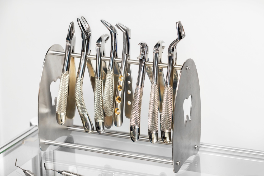 Close-up of a set of various instruments, stainless steel forceps in a dental clinic. Dentistry, orthodontics and medical instruments concept.. Dental instruments, a set of various forceps for removing teeth.