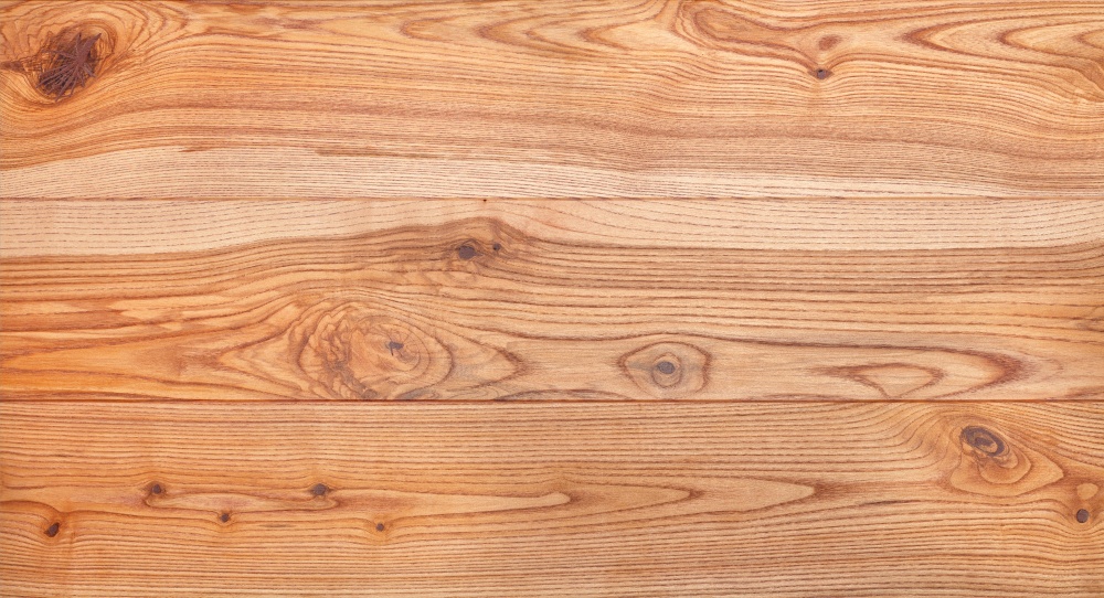 A beautiful pattern of ash planks in the form of a smooth wooden surface with horizontal lines of fibers, panoramic image for a banner.. Beautiful texture of a natural ash board with a horizontal grain pattern.