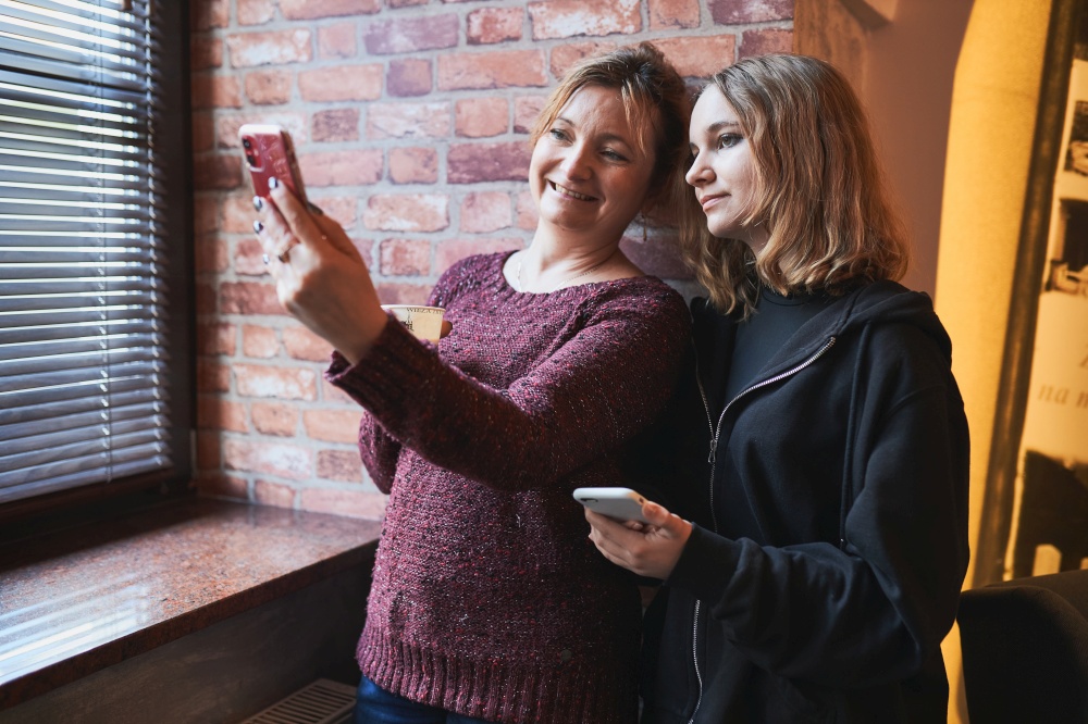 Women making video call on mobile phone.  Taking selfie photo using smartphone. Connecting remotely with family and friends