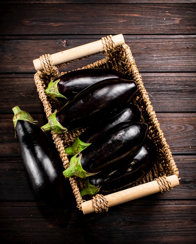 Box on a table with ripe eggplant. On a wooden background. High quality photo. Box on a table with ripe eggplant.