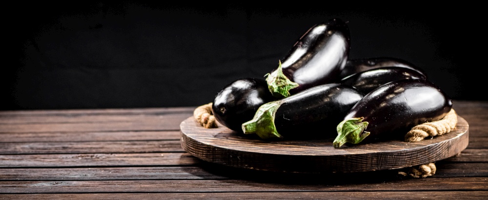 Ripe eggplant on a wooden tray. On a wooden background. High quality photo. Ripe eggplant on a wooden tray.