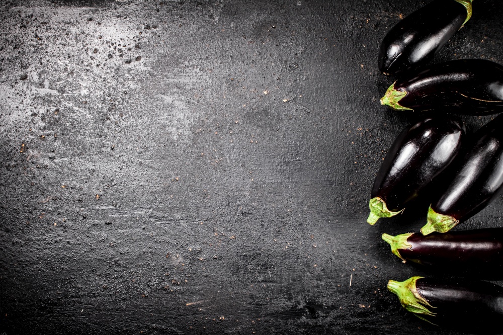Fresh homemade eggplant on the table. On a black background. High quality photo. Fresh homemade eggplant on the table.