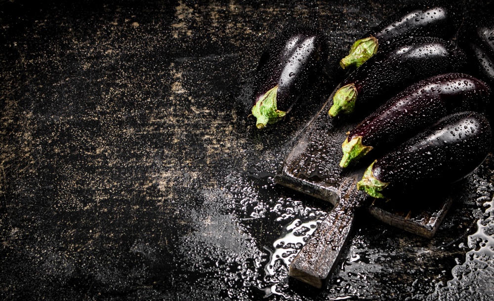 Ripe eggplant with droplets of water. On a black background. High quality photo. Ripe eggplant with droplets of water.