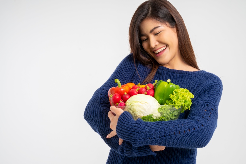 Portrait of beautiful smiling asian woman holding bowl full of fresh organic vegetables isolated on white background, concept of healthy food nutrition, Concept of healthy food nutrition, vegetarian