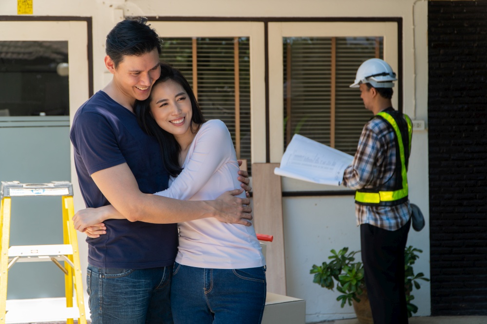 Happy and Smiling couple stand in front of constructor, handyman holding blueprint and checking details before renovations home, house improvement interior, Interior design, specialist concept