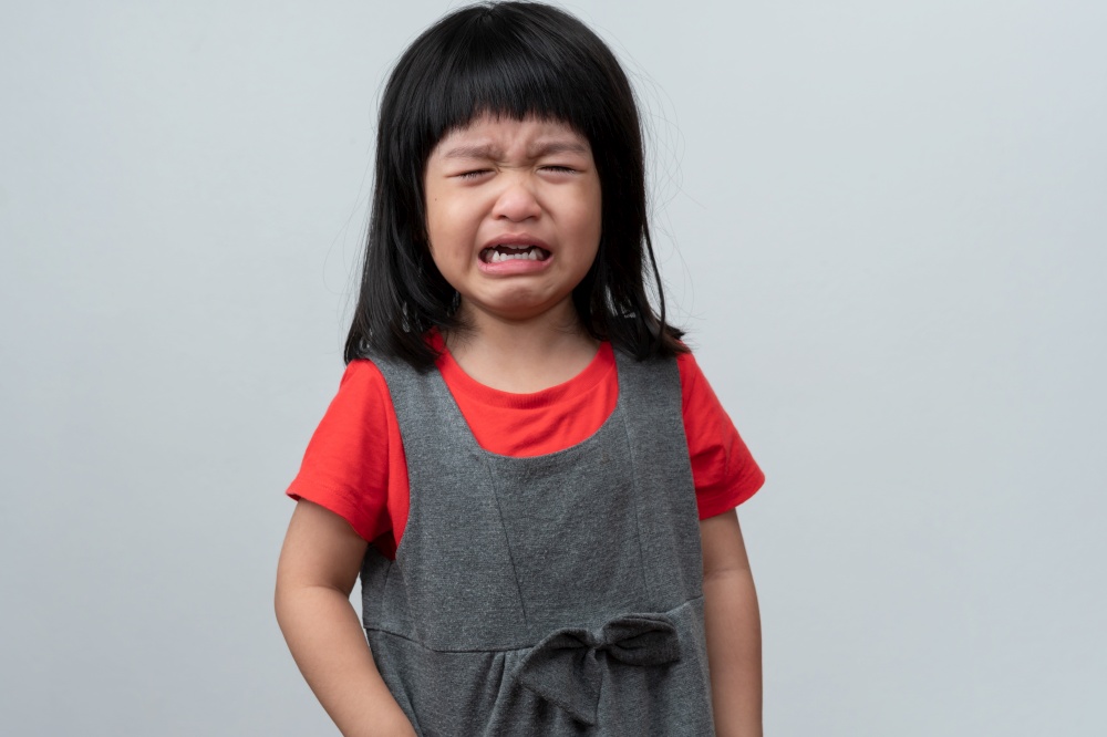 Portrait of Asian angry, sad and cry little girl on white isolated background, The emotion of a child when tantrum and mad, expression grumpy emotion. Kid emotional control concept
