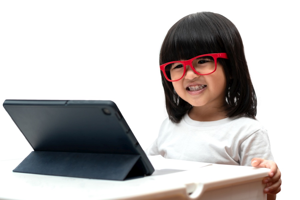 Little Asian Preschooler girl wearing red glasses and using tablet pc on white background, Asian girl talking and learning with a video call with a tablet, Educational concept for school kids.