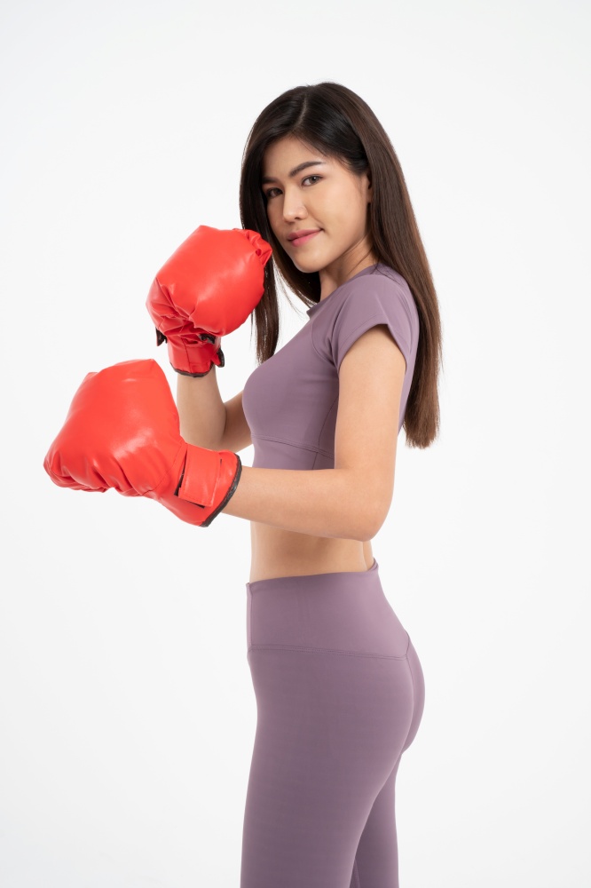 Portrait of beautiful Asian woman standing smile wearing the red boxing gloves,  studio shot isolated on white background, Concept of fitness, exercise and healthy