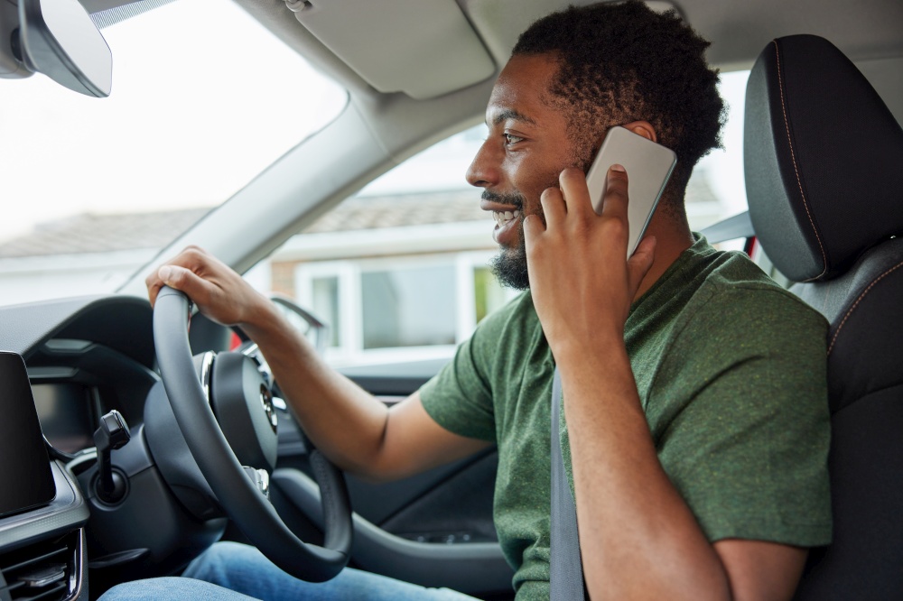 Man Talking On Mobile Phone Whilst Driving Car