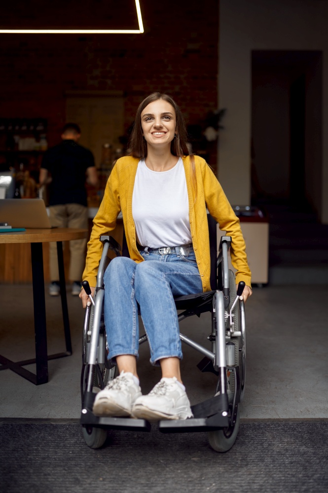 Disabled female student in wheelchair at the window, disability, bookshelf and university library interior on background. Handicapped young woman studying in college, paralyzed people get knowledge. Disabled female student in wheelchair at window