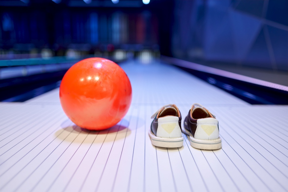 Ball and house shoes on the lane, game concept. Sport bowling equipment. Ball and house shoes, bowling, game concept