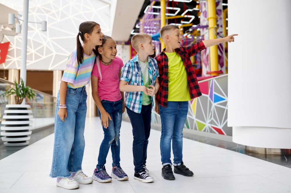 Cheerful children walking in entertainment center. Boys and girls having fun, kids spend the weekend on playground, happy childhood. Cheerful children walking in entertainment center