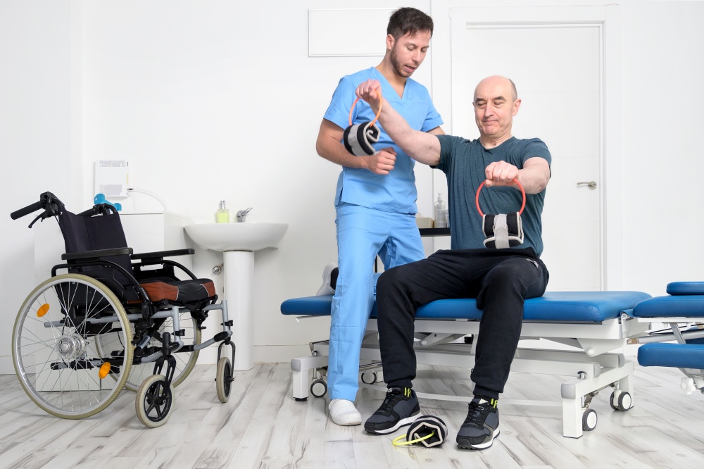 Man with disability doing recovery exercise with dumbbell. Man with Ataxy in recovery support therapy physiotherapy healthcare system. High quality photo.. Man with disability doing recovery exercise with dumbbell. Man with Ataxy in recovery support therapy physiotherapy healthcare system.
