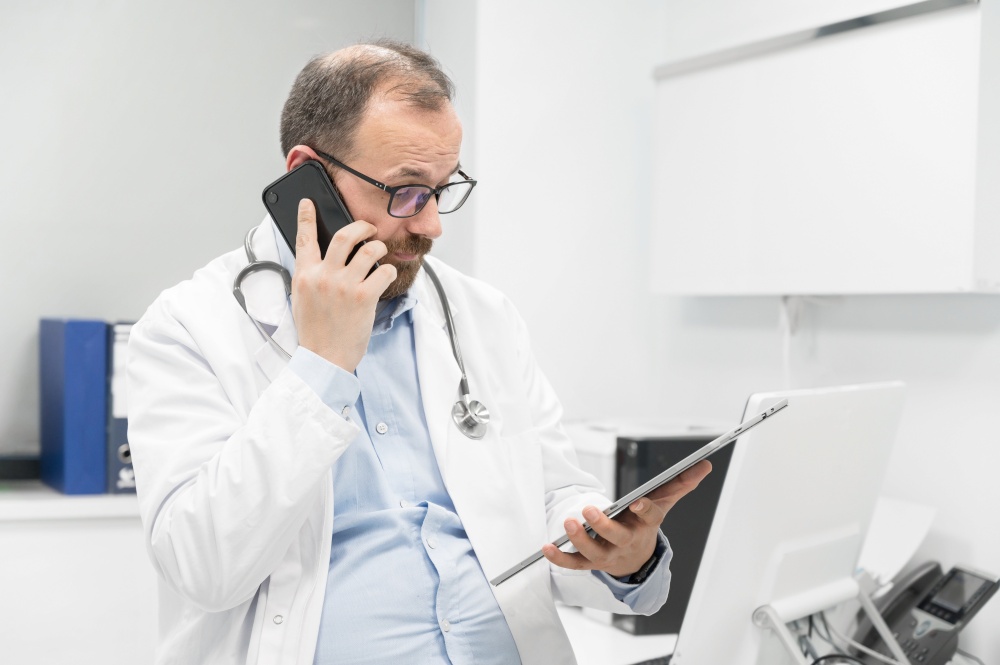 Doctor in office talking on phone. High quality photography.. Doctor in office talking on phone