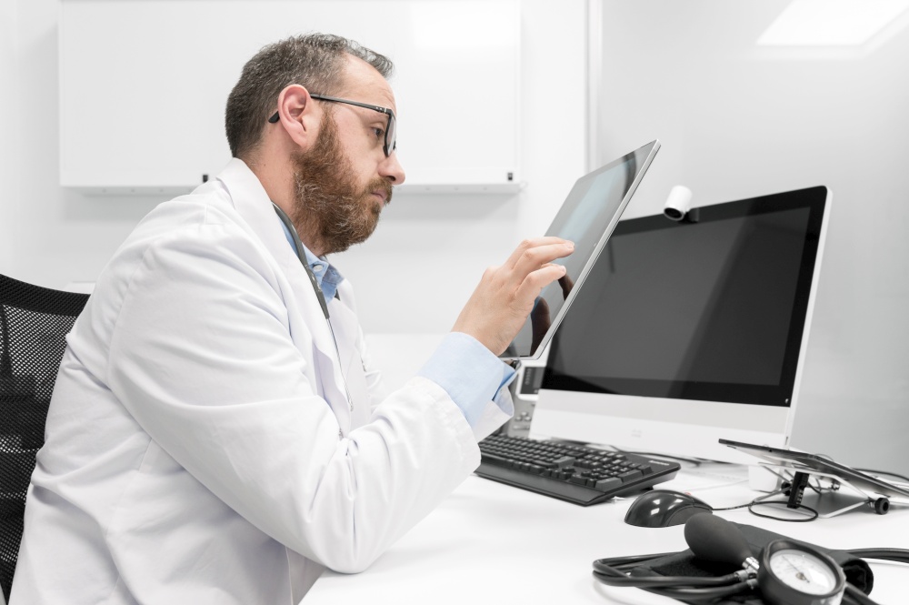 Doctor using his tablet computer at work. High quality photo. Doctor using his tablet computer at work