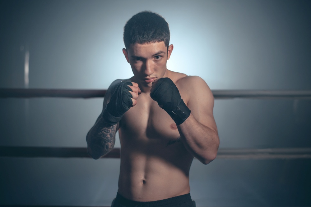 Boxer, man posing in bandage on boxing ring. Fitness and boxing concept. High quality photo. Boxer, man posing in bandage on boxing ring. Fitness and boxing concept.