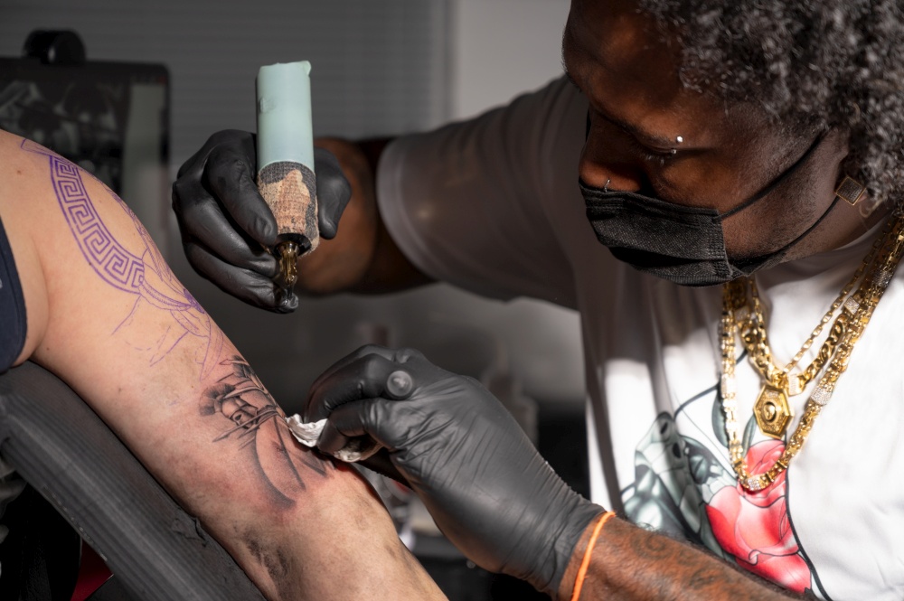Cinematic shot of a Tattoo artist creating Body art at the tattoo studio. High quality photography. Cinematic shot of a Tattoo artist creating Body art at the tattoo studio