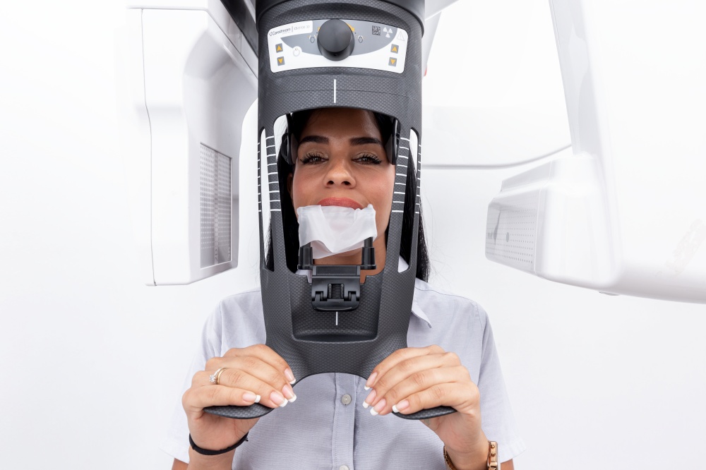 Female client with the face into a teeth whitening machine in a dental clinic. Woman with the face into a teeth whitening machine in a dental clinic