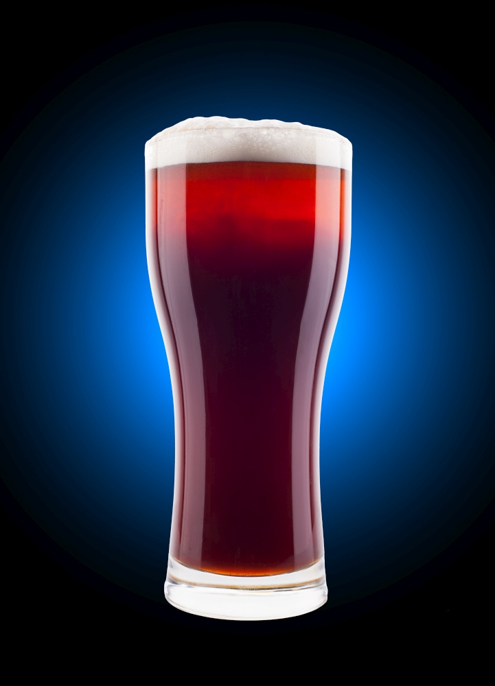Glass of beer with foam on top in close up with color background. Glass of beer with foam