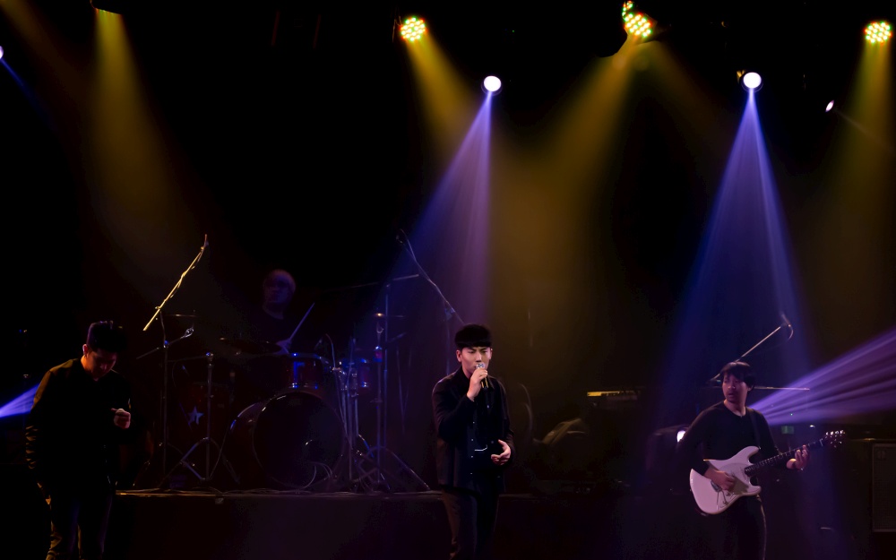 A band showing their performance on stage with colorful spot light. Entertainment and Concert Concept.