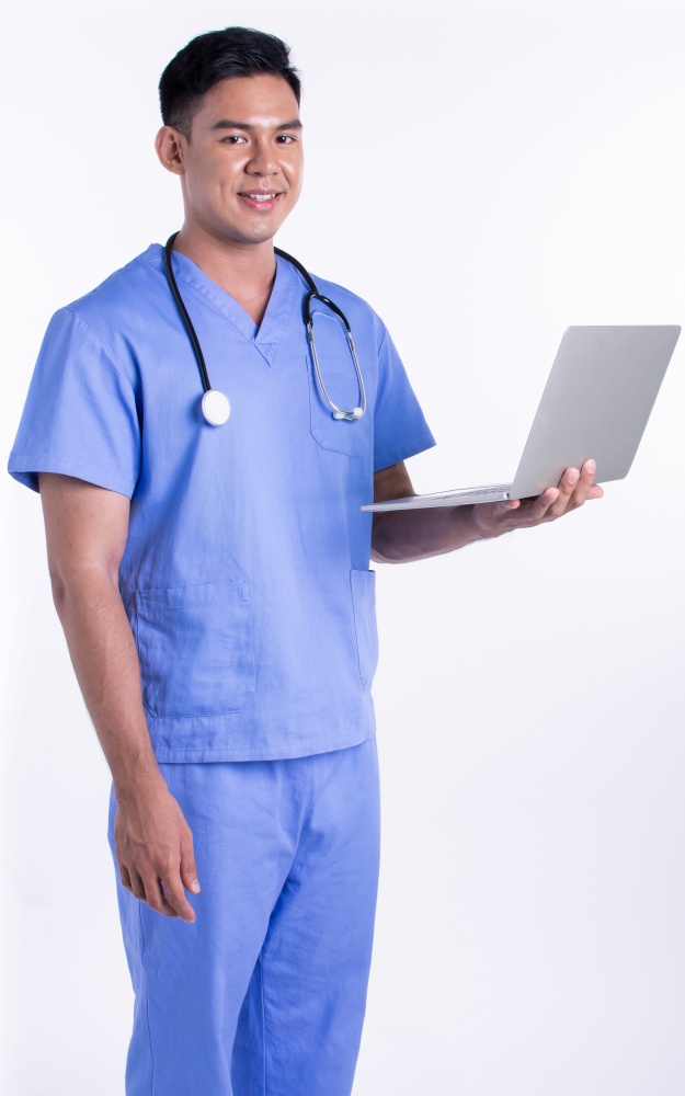 Asian young male doctor wearing uniform and using laptop for online service while standing on white background with copy space. Medical and Technology Concept.