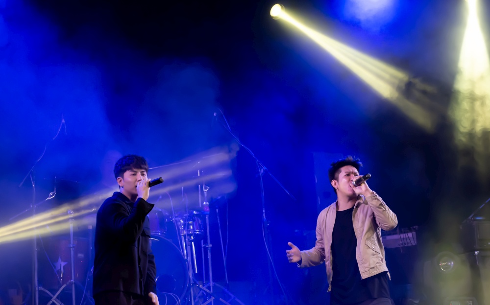Asian male singers showing their porformance on stage. Entertainment and Concert Concept.