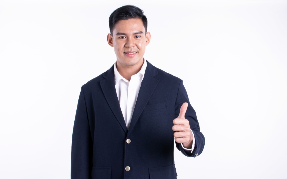 Portrait of successful asian young business man wearing formal suit and shirt, smiling with confidence and standing on white background.