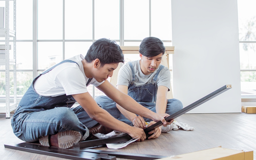 Asian handsome men are making an assembly of a furniture at home. Interior design and DIY Concept.