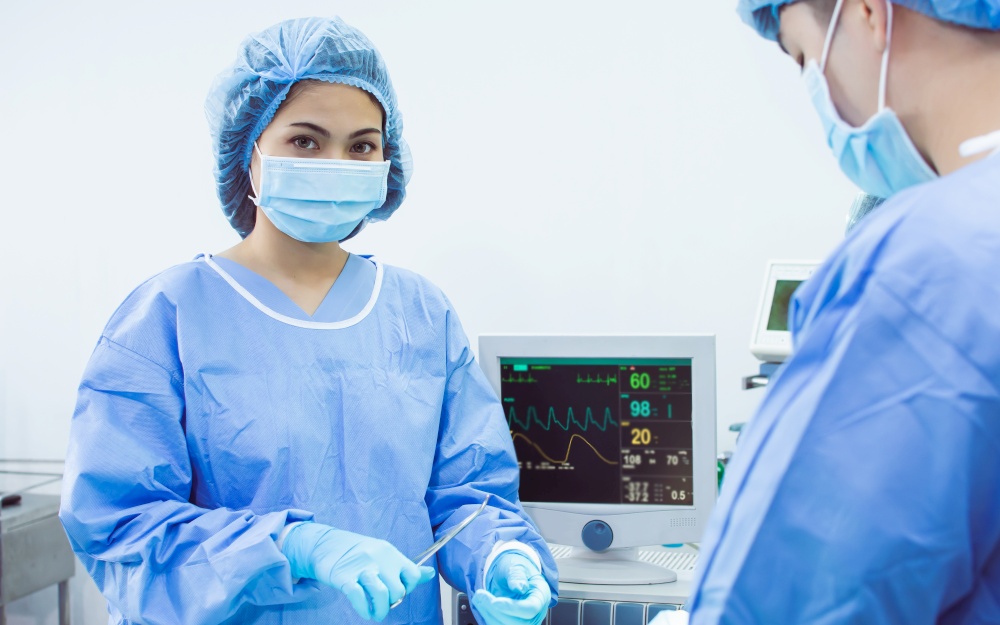 Portrait of asian female doctor with blur background of medical team doing surgical operation at hospital