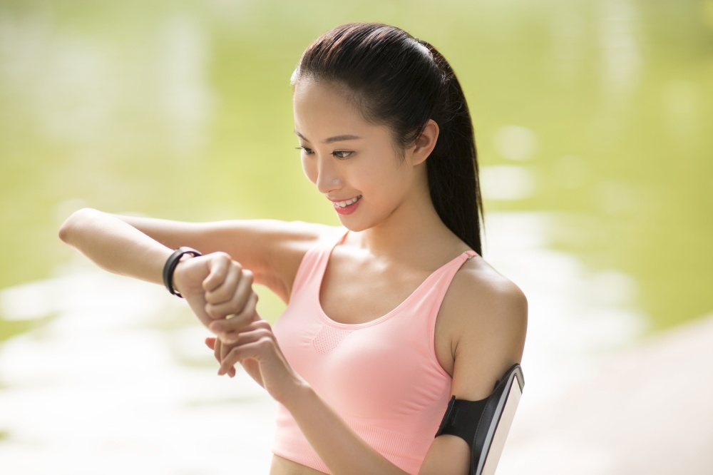 A fitness woman looking at her exercise bracelet