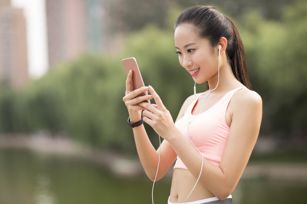 A fitness woman listening to music on her phone