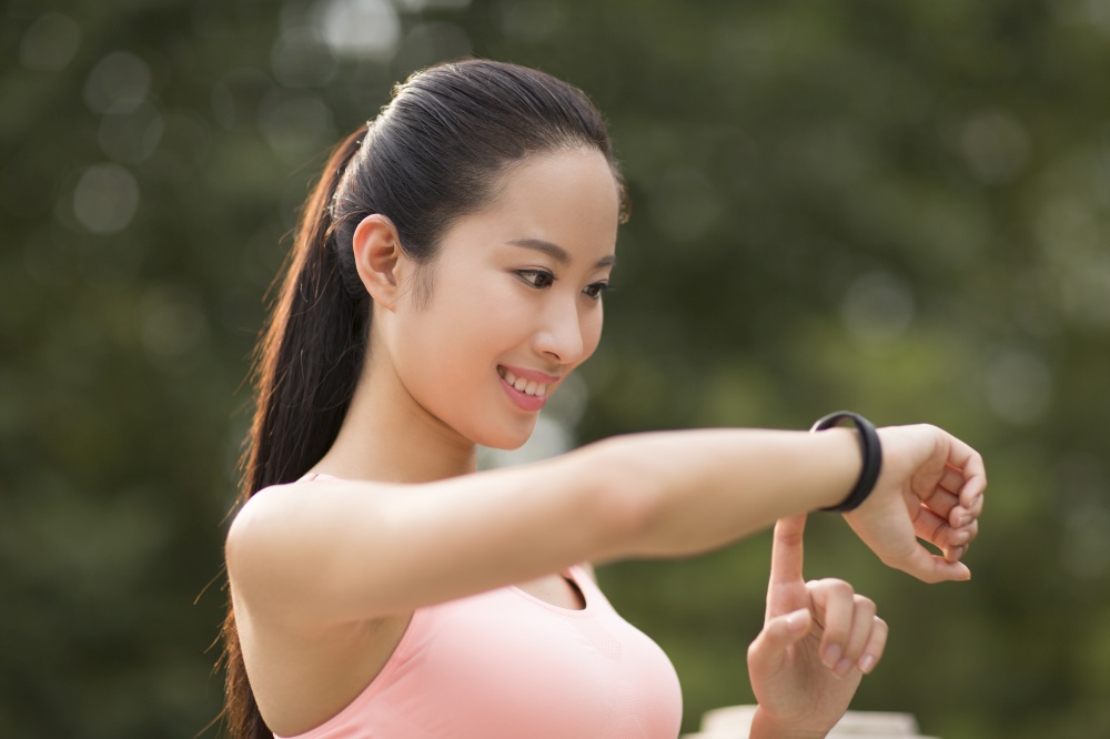 A fitness woman looking at her exercise bracelet